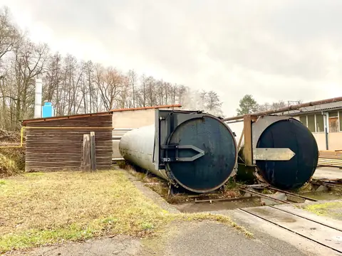 Deux autoclaves de traitement posés sur des rails, à l’extérieur d’un site