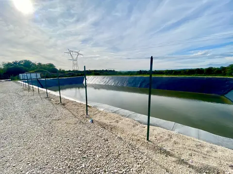 Bassin aménagé en bordure d’un site industriel, sous un ciel dégagé