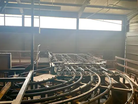 Structure métallique courbe d’un équipement, sous la toiture d’un atelier