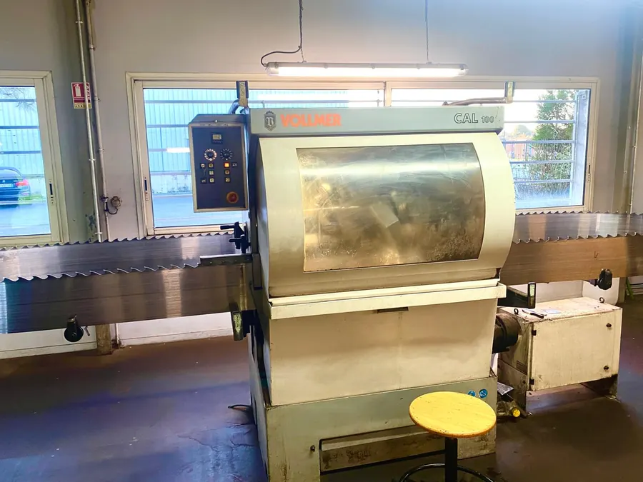 Machine de coupe industrielle équipée d’un convoyeur dans un atelier