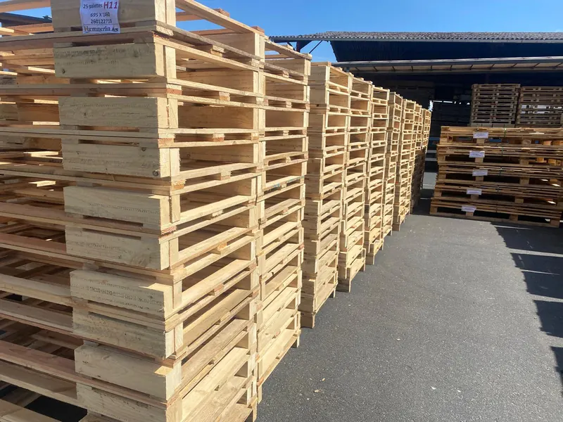 Piles de palettes en bois stockées dans un entrepôt