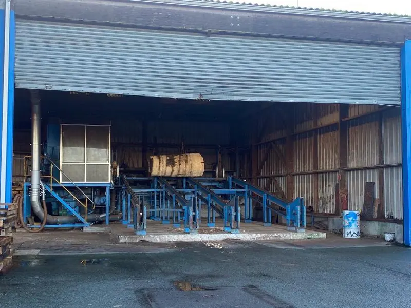 Hangar industriel ouvert, avec une voie de circulation devant l’entrée