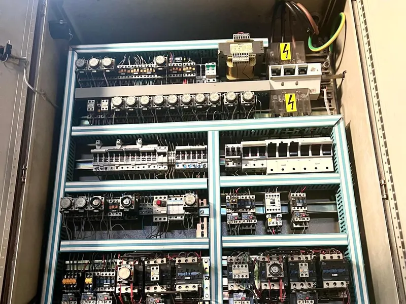 Armoire électrique ouverte avec ses appareillages dans un atelier
